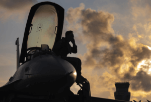 Airman sitting on his plane in front of the sunset