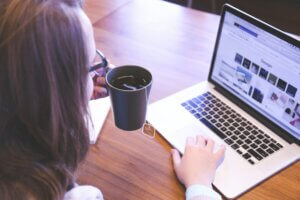 Woman on a Laptop holding a tea cup